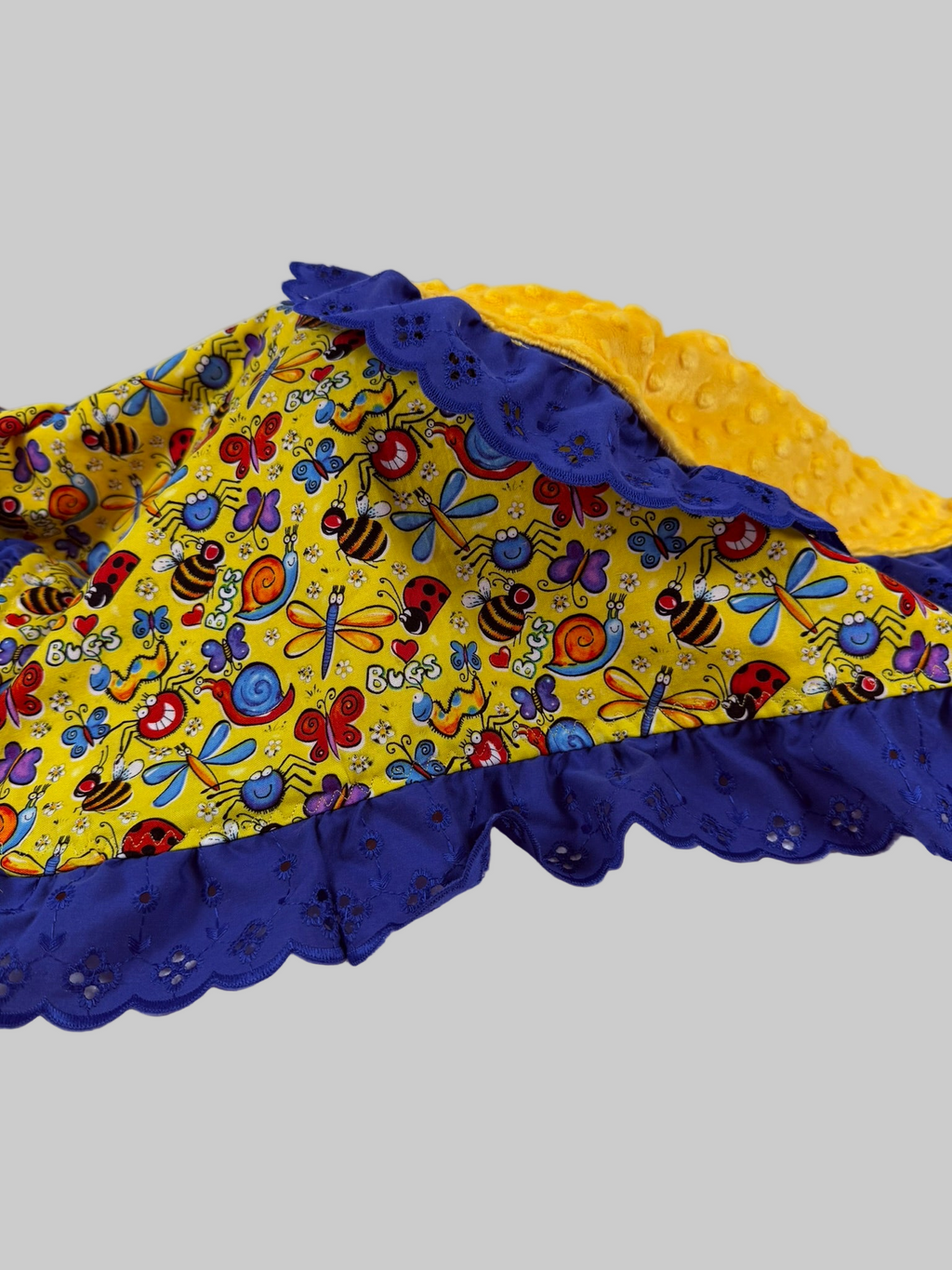 Colorful baby blanket with blue and yellow edges on a white background