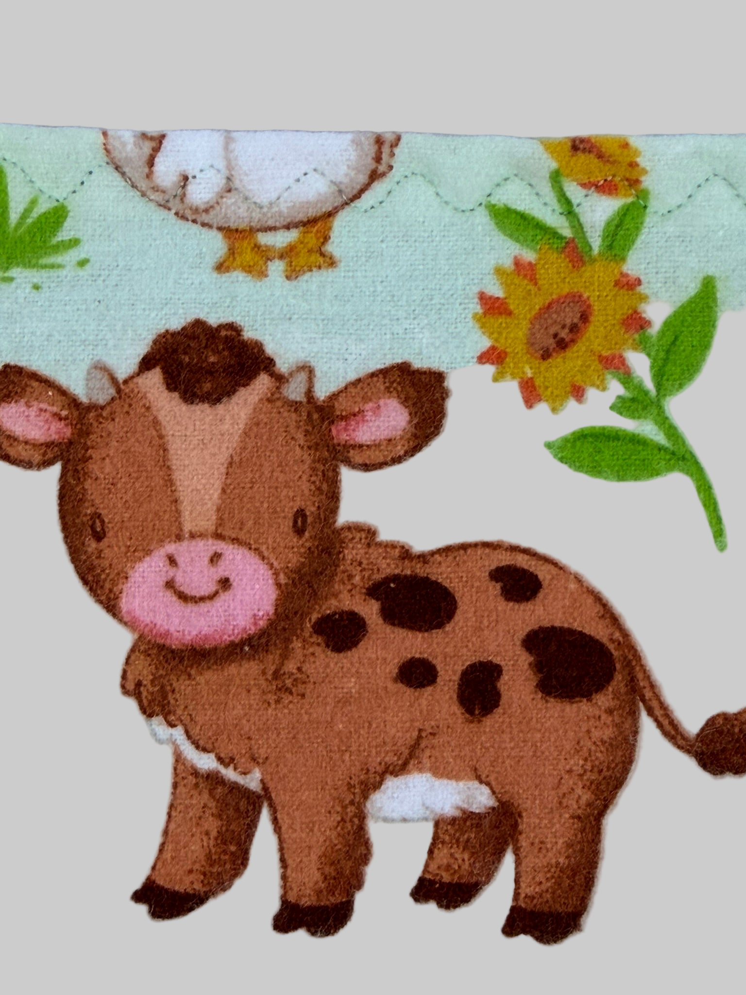 Cow illustration on a fabric with floral and animal patterns