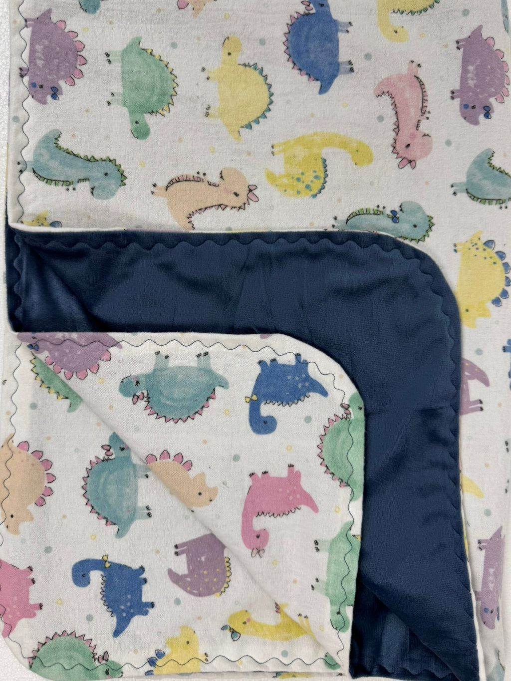 Baby blanket with colorful dinosaur pattern on a white background