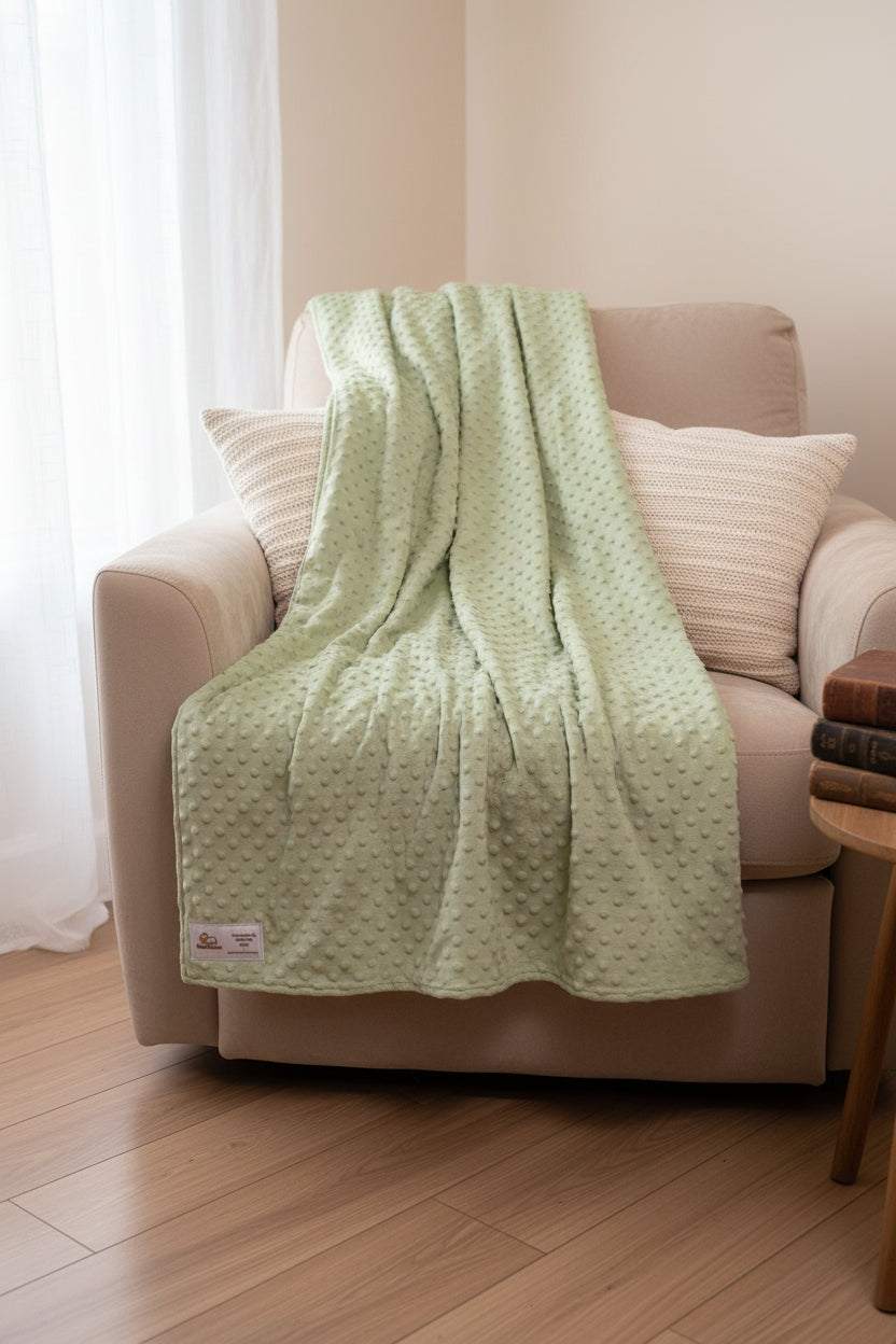 Green textured blanket on a white surface with a label
